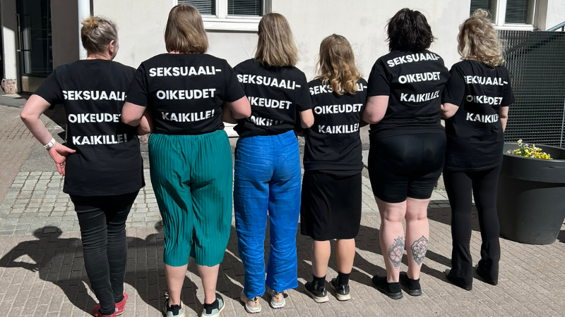 Kuvassa kuusi henkilöä rivissä selkä kameraan päin. Jokaisella paita jossa lukee Seksuaalioikeudet kaikille!