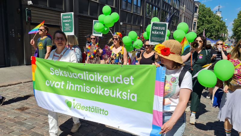 Pride-kulkue. Väestöliiton banneri, jossa lukee seksuaalioikeudet ovat ihmisoikeuksia. Kesäinen sää ja ihmisiä.